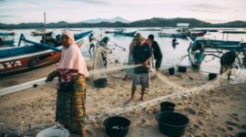 Seorang nelayan lokal memanfaatkan metode pancing tradisional ramah lingkungan saat matahari terbenam untuk mendukung keberlanjutan ekosistem laut Nusantara.