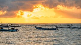Suasana senja di sebuah perkampungan nelayan tradisional Indonesia memperlihatkan perahu-perahu kayu bersandar rapi setelah seharian berlayar mencari ikan.