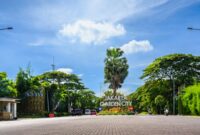 Seorang pejalan kaki menggunakan payung untuk melindungi diri dari terik matahari yang menyengat di kawasan bisnis Jakarta, menggambarkan dampak perubahan suhu udara ekstrem di kawasan perkotaan.