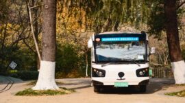 Suasana bus listrik perkotaan yang melintasi jalanan bersih di pagi hari, melambangkan transisi transportasi publik ramah lingkungan demi menekan emisi gas buang kendaraan.