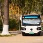 Suasana bus listrik perkotaan yang melintasi jalanan bersih di pagi hari, melambangkan transisi transportasi publik ramah lingkungan demi menekan emisi gas buang kendaraan.