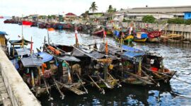 Suasana pagi hari di salah satu desa nelayan pesisir Indonesia saat para warga bergotong-royong menyiapkan perahu dan jaring sebelum melaut.