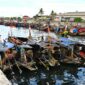 Suasana pagi hari di salah satu desa nelayan pesisir Indonesia saat para warga bergotong-royong menyiapkan perahu dan jaring sebelum melaut.