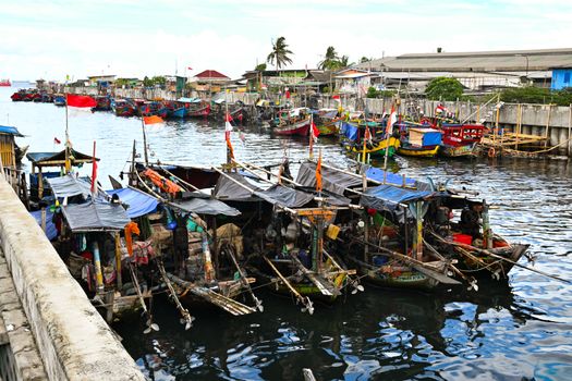 Suasana pagi hari di salah satu desa nelayan pesisir Indonesia saat para warga bergotong-royong menyiapkan perahu dan jaring sebelum melaut.