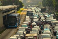 Deretan kendaraan yang terjebak kemacetan di jalan protokol kota menyemburkan asap emisi gas buang yang berpotensi menurunkan kualitas udara dan mengganggu kesehatan masyarakat sekitar.