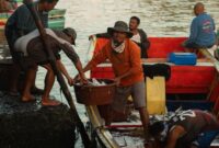 Seorang nelayan tradisional di perairan pesisir Indonesia menggunakan teknik pancing ulur ramah lingkungan untuk menangkap ikan tanpa merusak ekosistem terumbu karang.