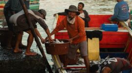 Seorang nelayan tradisional di perairan pesisir Indonesia menggunakan teknik pancing ulur ramah lingkungan untuk menangkap ikan tanpa merusak ekosistem terumbu karang.