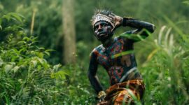 Anggota masyarakat adat bersama pemuda lokal menggunakan perangkat pemetaan digital untuk mendokumentasikan batas-batas hutan ulayat mereka di kawasan pegunungan Indonesia.