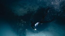 Seorang penyelam lokal sedang merawat struktur pembibitan karang buatan di kawasan konservasi perairan Indonesia sebagai bagian dari upaya restorasi ekosistem laut.
