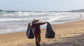 Pemandangan pesisir pantai Indonesia yang memperlihatkan kontras antara keindahan laut biru dan pentingnya menjaga ekosistem dari ancaman limbah plastik.
