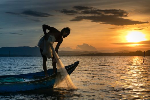 Seorang nelayan tradisional di perairan pesisir Indonesia sedang menarik jaring ramah lingkungan untuk menjaga populasi ikan dan kelestarian terumbu karang.