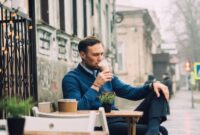 Seorang warga urban menikmati secangkir kopi pagi di tengah suasana perkotaan yang hijau, mencerminkan perpaduan rutinitas harian dan kesadaran akan gaya hidup rendah emisi karbon.