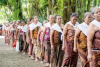 Seorang tetua adat berjalan menelusuri kawasan hutan lindung di Kalimantan dengan latar tutupan pohon rindang yang terjaga kelestariannya. Praktik pengelolaan tradisional masyarakat setempat terbukti efektif menjaga keanekaragaman hayati dari ancaman deforestasi.