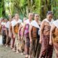 Seorang tetua adat berjalan menelusuri kawasan hutan lindung di Kalimantan dengan latar tutupan pohon rindang yang terjaga kelestariannya. Praktik pengelolaan tradisional masyarakat setempat terbukti efektif menjaga keanekaragaman hayati dari ancaman deforestasi.