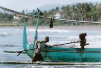 Seorang nelayan tradisional di perairan Indonesia sedang menggunakan teknik pancing ulur yang ramah lingkungan untuk menjaga kelestarian ekosistem laut.