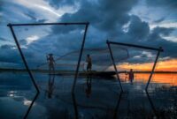 Seorang nelayan tradisional di pesisir Indonesia menggunakan teknik pancing ulur yang ramah lingkungan untuk menjaga kelestarian ekosistem laut. Metode penangkapan terukur ini menjadi tumpuan utama masa depan industri perikanan berkelanjutan di Nusantara.