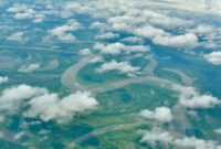 Pemandangan dari udara memperlihatkan batas ketat antara tutupan hutan hujan tropis alami di Indonesia dengan kawasan perkebunan yang mulai meluas ke wilayah dalam rimba.