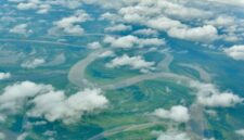 Pemandangan dari udara memperlihatkan batas ketat antara tutupan hutan hujan tropis alami di Indonesia dengan kawasan perkebunan yang mulai meluas ke wilayah dalam rimba.