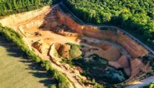Pemandangan udara memperlihatkan bukit-bukit yang terkelupas akibat aktivitas pertambangan terbuka, memperlihatkan dampak langsung pengerukan tanah terhadap ekosistem hutan tropis Nusantara.