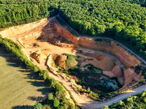Pemandangan udara memperlihatkan bukit-bukit yang terkelupas akibat aktivitas pertambangan terbuka, memperlihatkan dampak langsung pengerukan tanah terhadap ekosistem hutan tropis Nusantara.