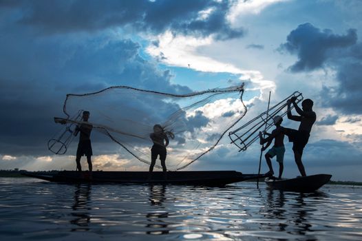 Seorang nelayan tradisional di perairan pesisir Indonesia sedang merapikan jaring pancing ramah lingkungan saat matahari terbenam untuk menjaga populasi ikan lokal.